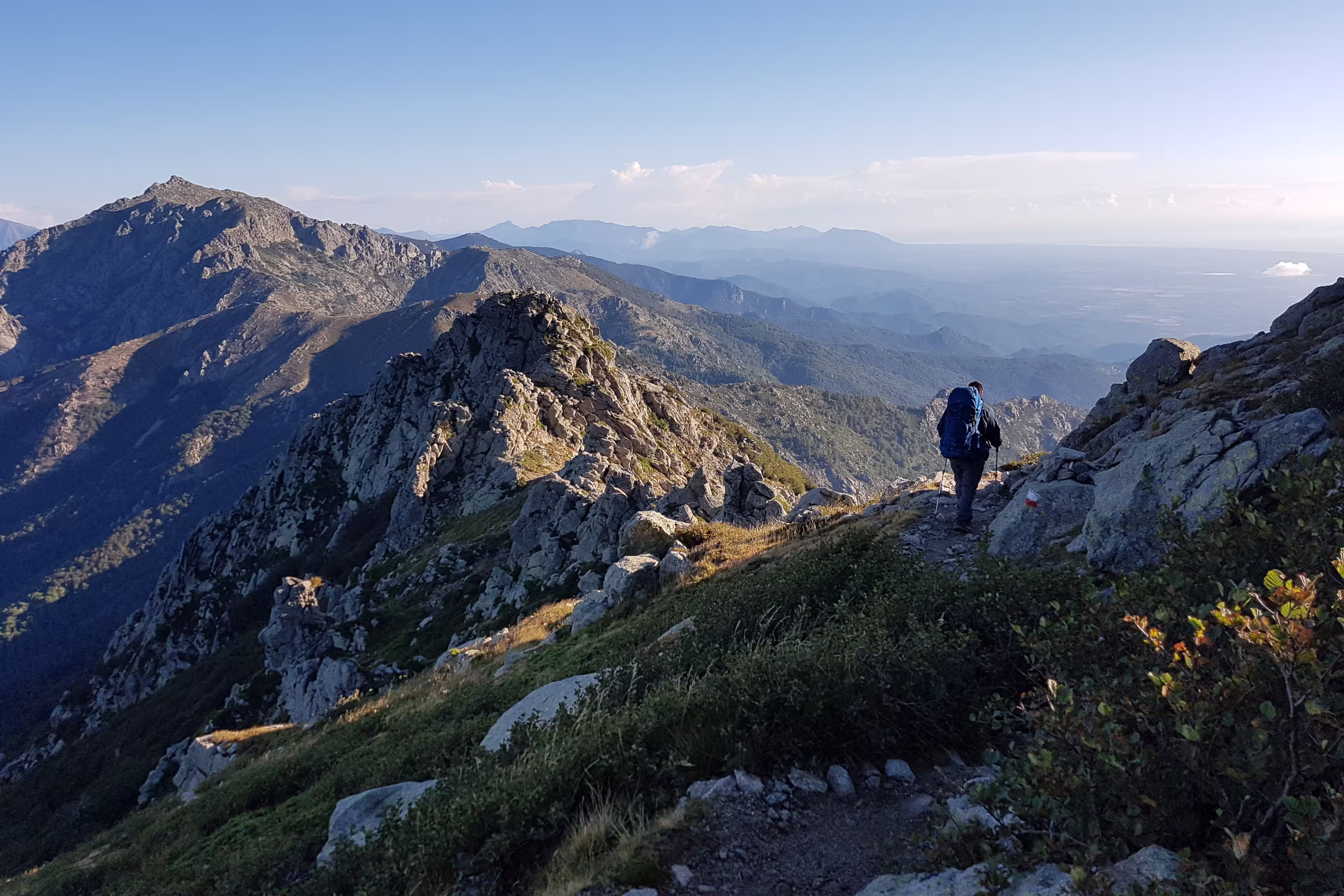 A hiker walking through the mountains of Corsica on the GR20