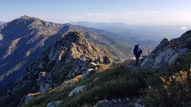 A hiker walking through the mountains of Corsica on the GR20