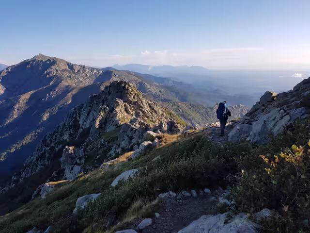 A hiker walking through the mountains of Corsica on the GR20