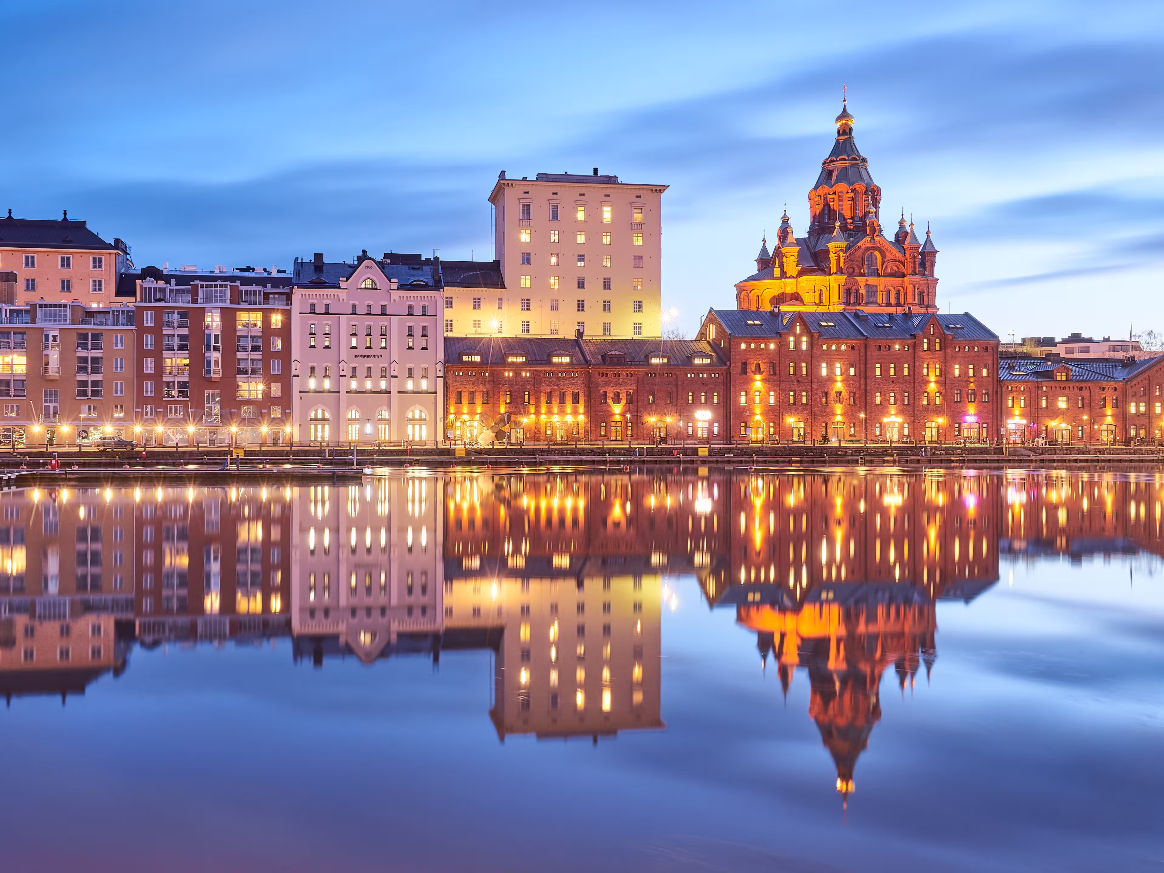 Evening view of a quay in Helsinki featuring the Uspenskin cathedral