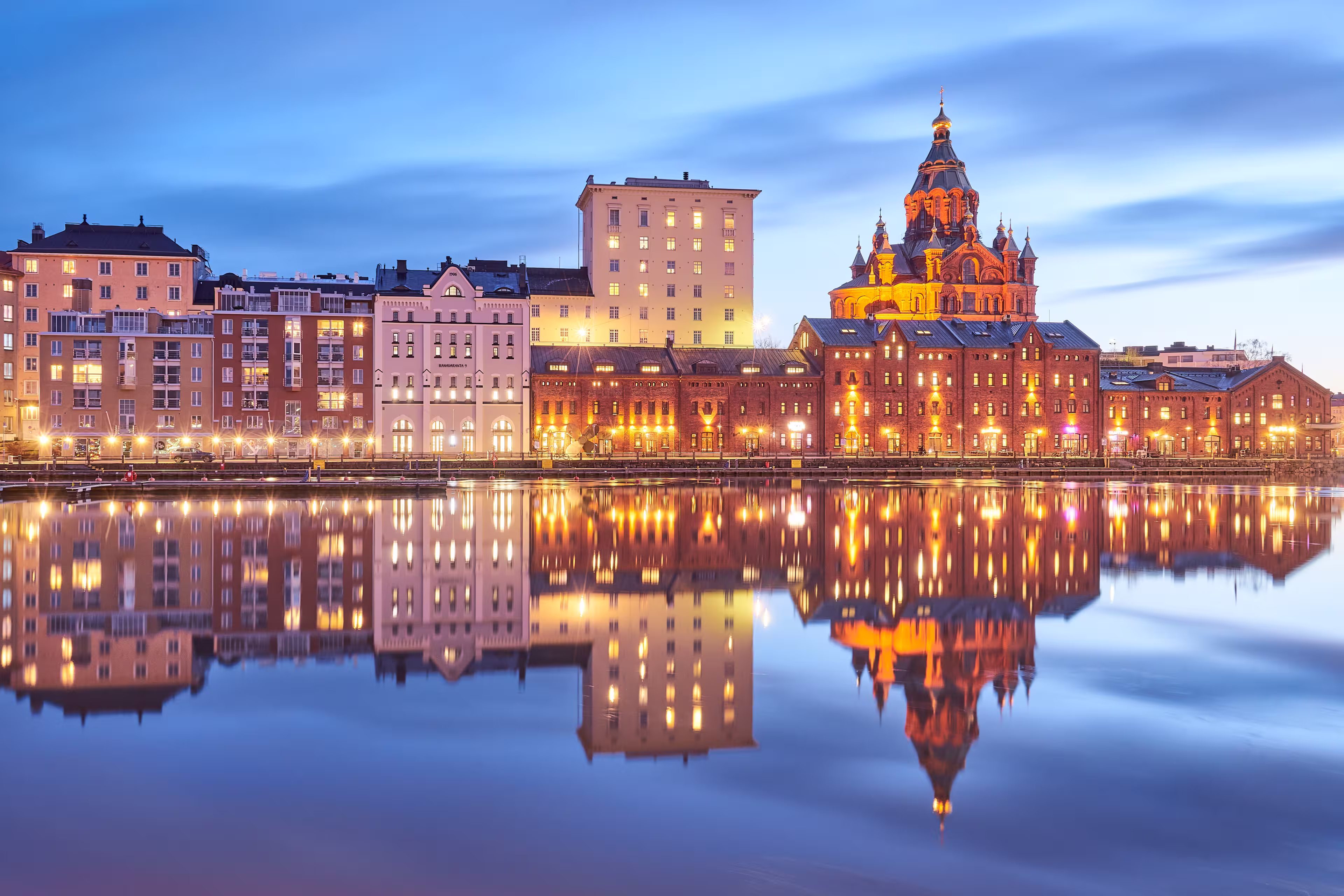 Evening view of a quay in Helsinki featuring the Uspenskin cathedral