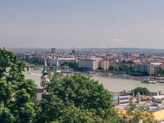 Tour group on balcony looks over river between Buda and Pest