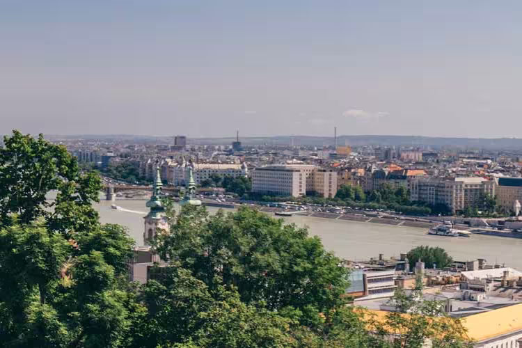 Tour group on balcony looks over river between Buda and Pest