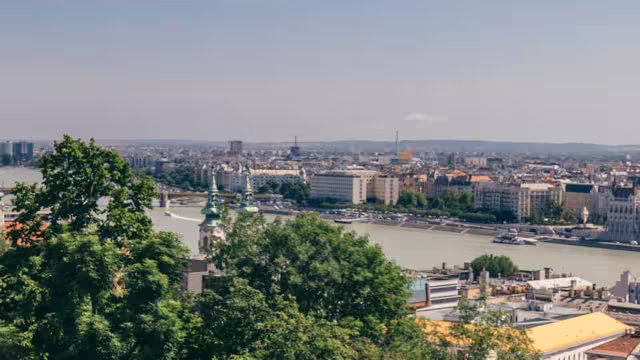 Tour group on balcony looks over river between Buda and Pest