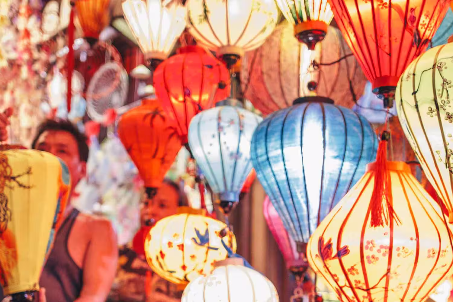 Traveller looks at lanterns at local market in Hoi An, Vietnam