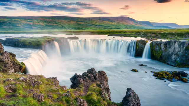 Majestic landscape of Godafoss waterfall or waterfall of the gods flowing and colorful sunset sky on Skjalfandafljot river in summer at Northern Iceland