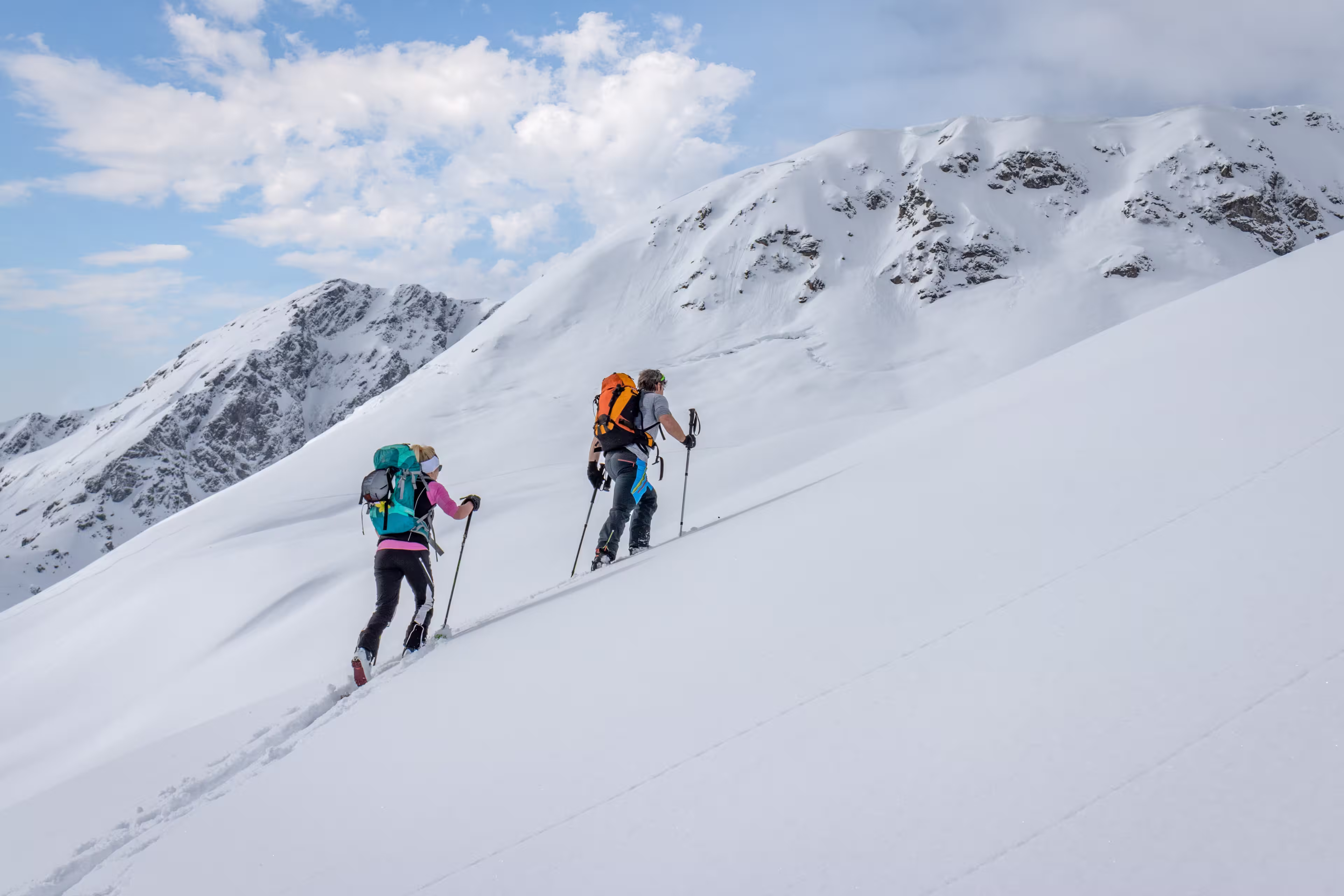 Ski touring couple hiking up a summit in the alps