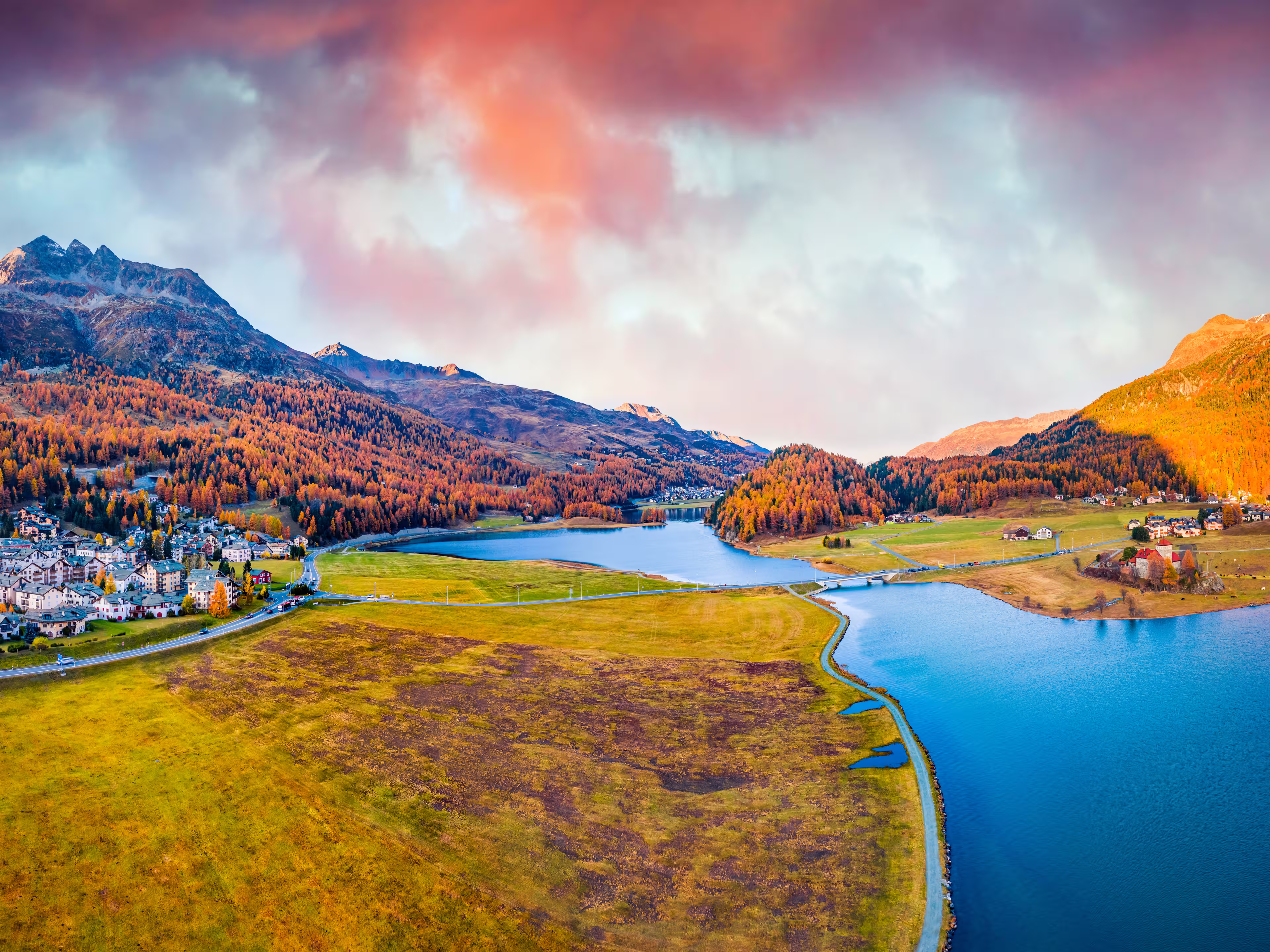 View from flying drone. Amazing autumn scene of Silvaplana village, Maloja Region. Aerial morning view of Swiss Alps. Spectacular evening landscape of Silvaplanersee lake. Traveling concept background