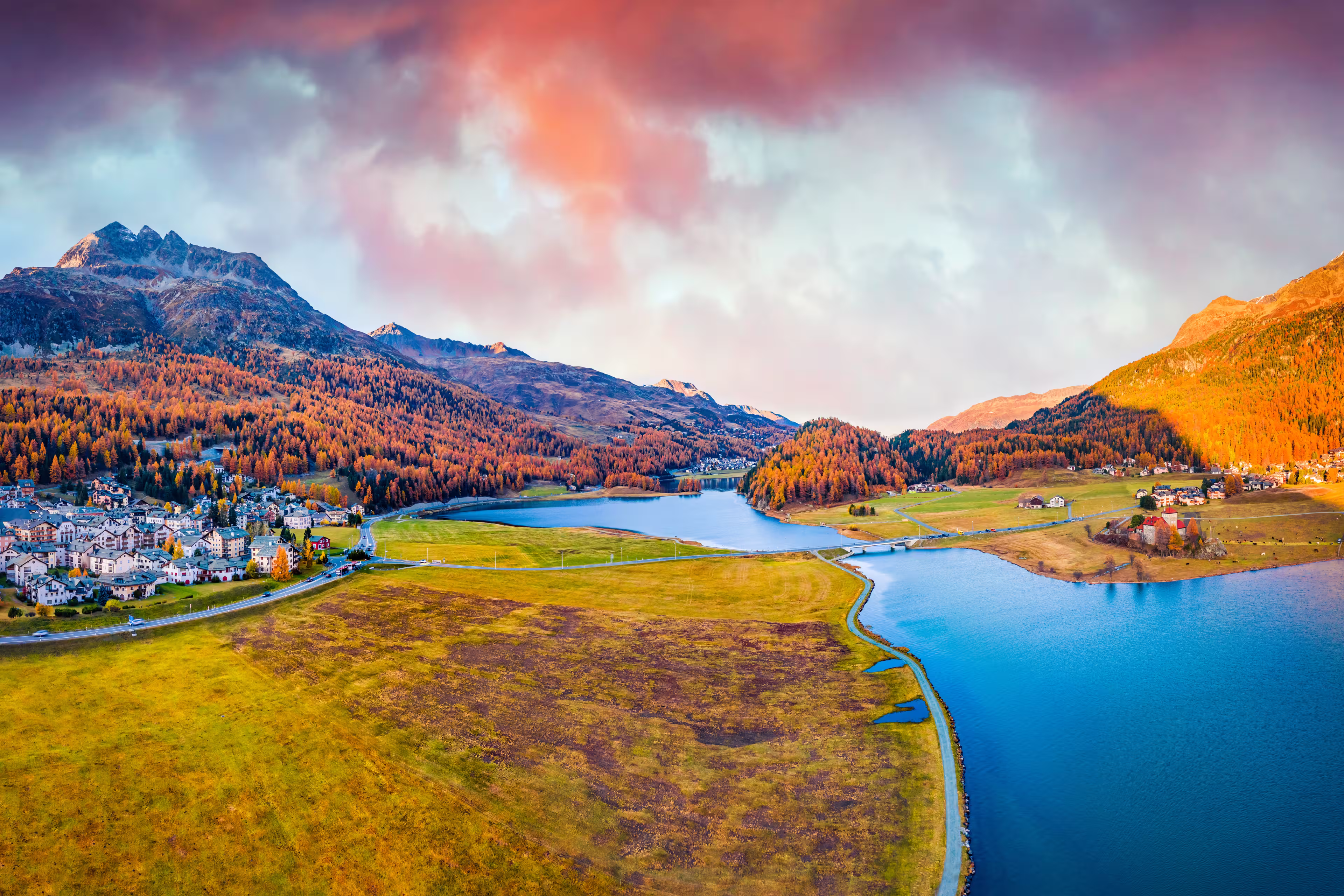 View from flying drone. Amazing autumn scene of Silvaplana village, Maloja Region. Aerial morning view of Swiss Alps. Spectacular evening landscape of Silvaplanersee lake. Traveling concept background
