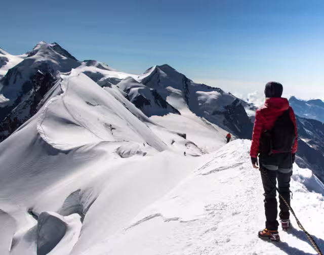 Hiker woman on top of Breithorn mountain, 4164 m above sea level. Zermatt, Pennine Alps, Switzerland, Europe.