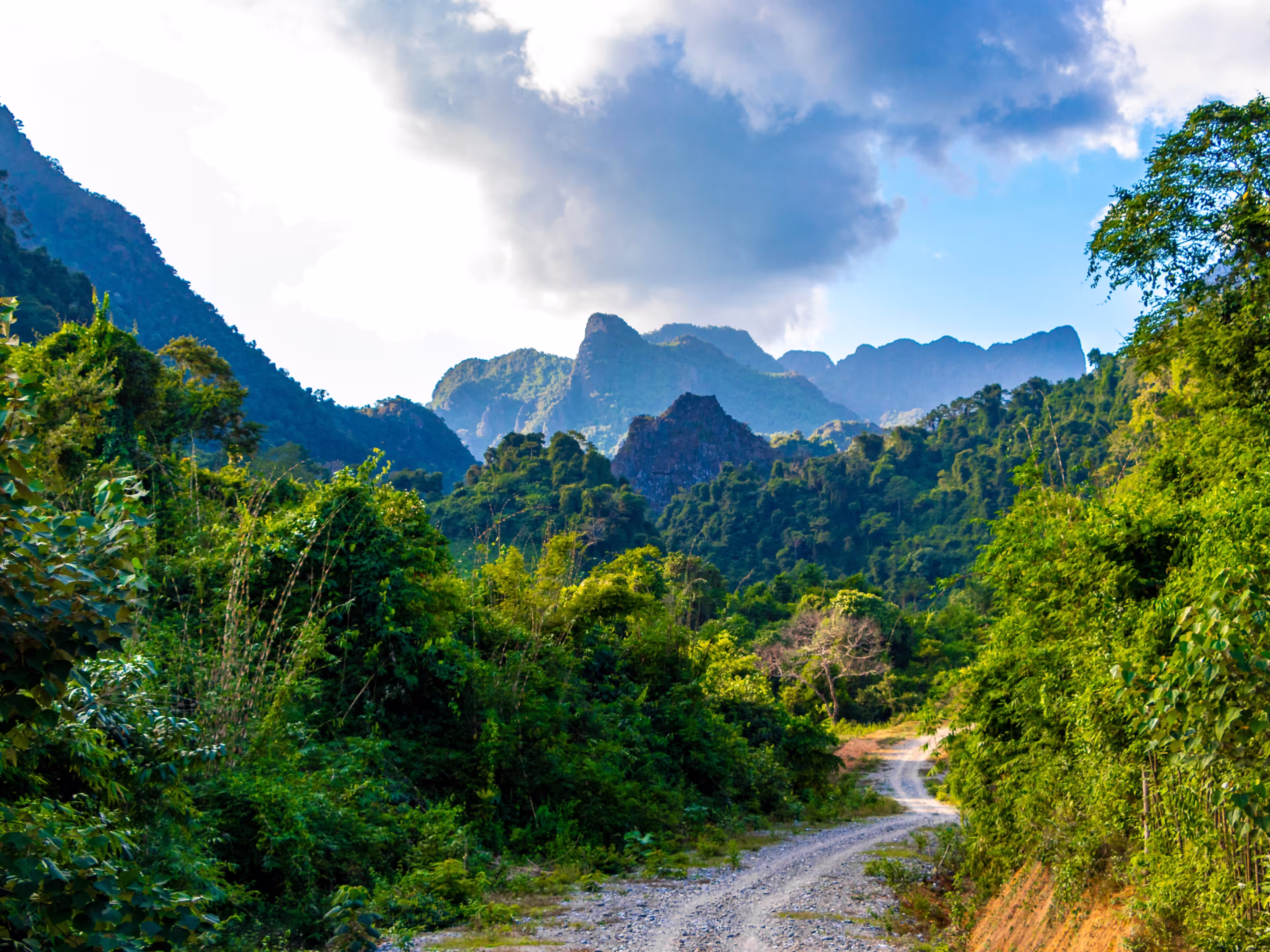 Mountain peak landscape with tropical forest jungle hills rocks and walking hiking path street road in Vang Vieng Vientiane Province Laos in Southeastasia Asia.