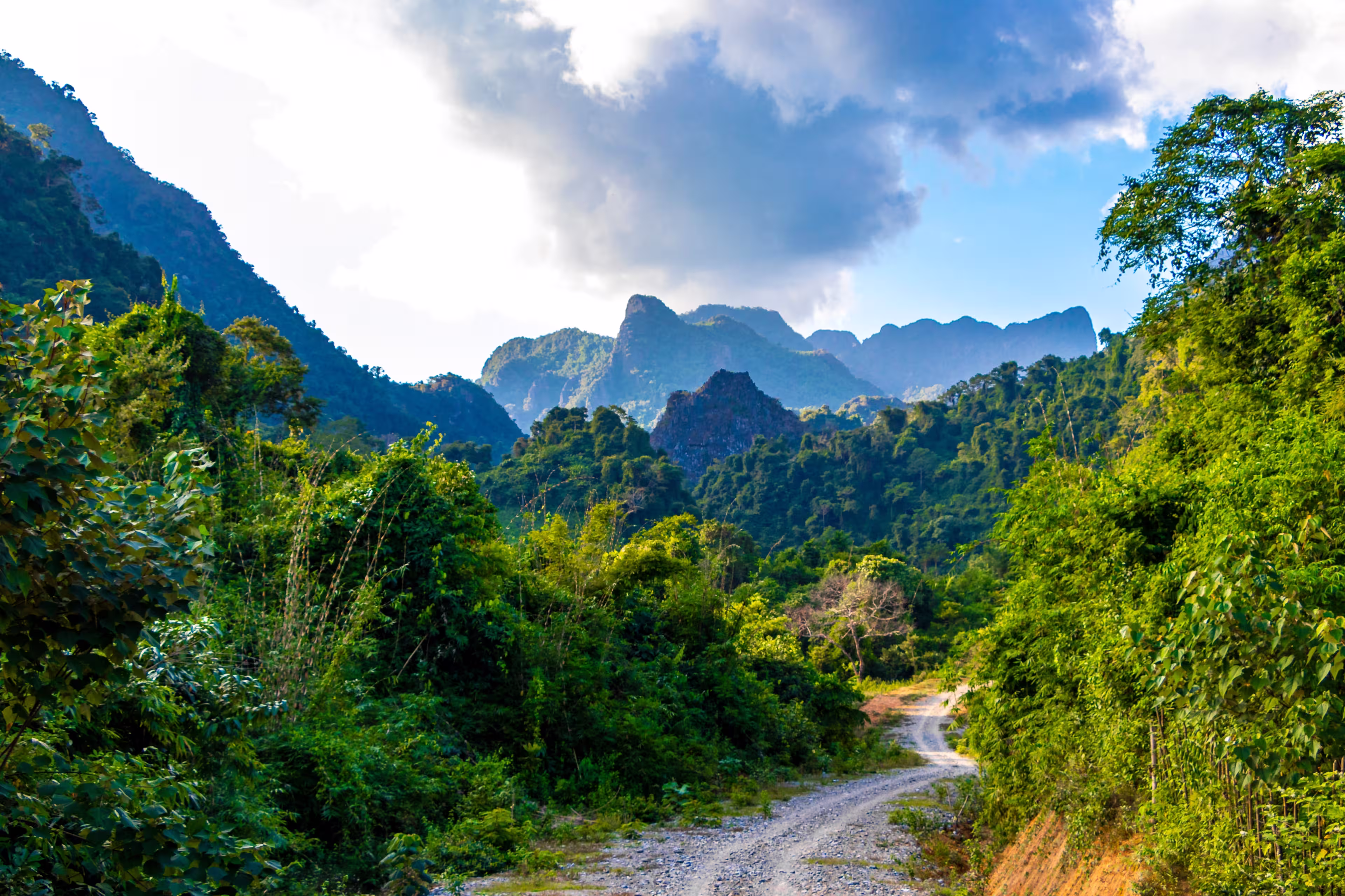 Mountain peak landscape with tropical forest jungle hills rocks and walking hiking path street road in Vang Vieng Vientiane Province Laos in Southeastasia Asia.
