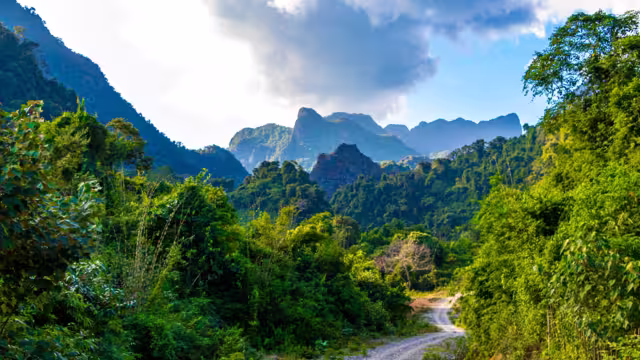Mountain peak landscape with tropical forest jungle hills rocks and walking hiking path street road in Vang Vieng Vientiane Province Laos in Southeastasia Asia.