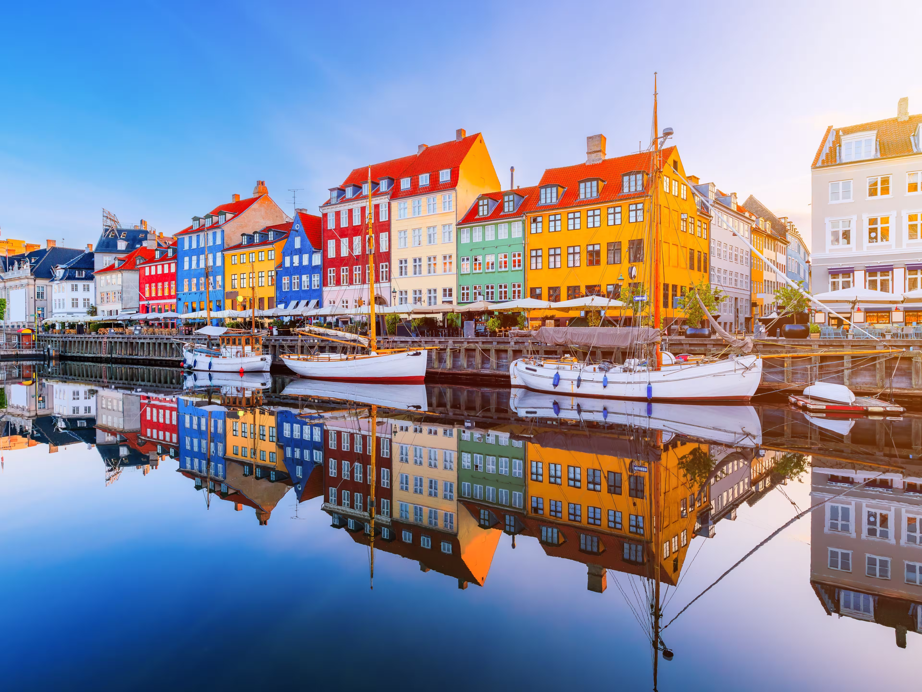 Copenhagen, Denmark. Nyhavn waterfront, colourful buliding facades and old ships along the canal.