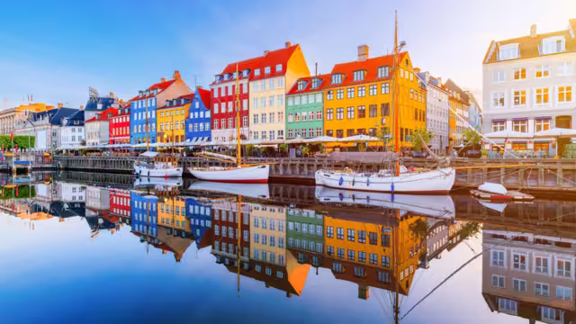 Copenhagen, Denmark. Nyhavn waterfront, colourful buliding facades and old ships along the canal.
