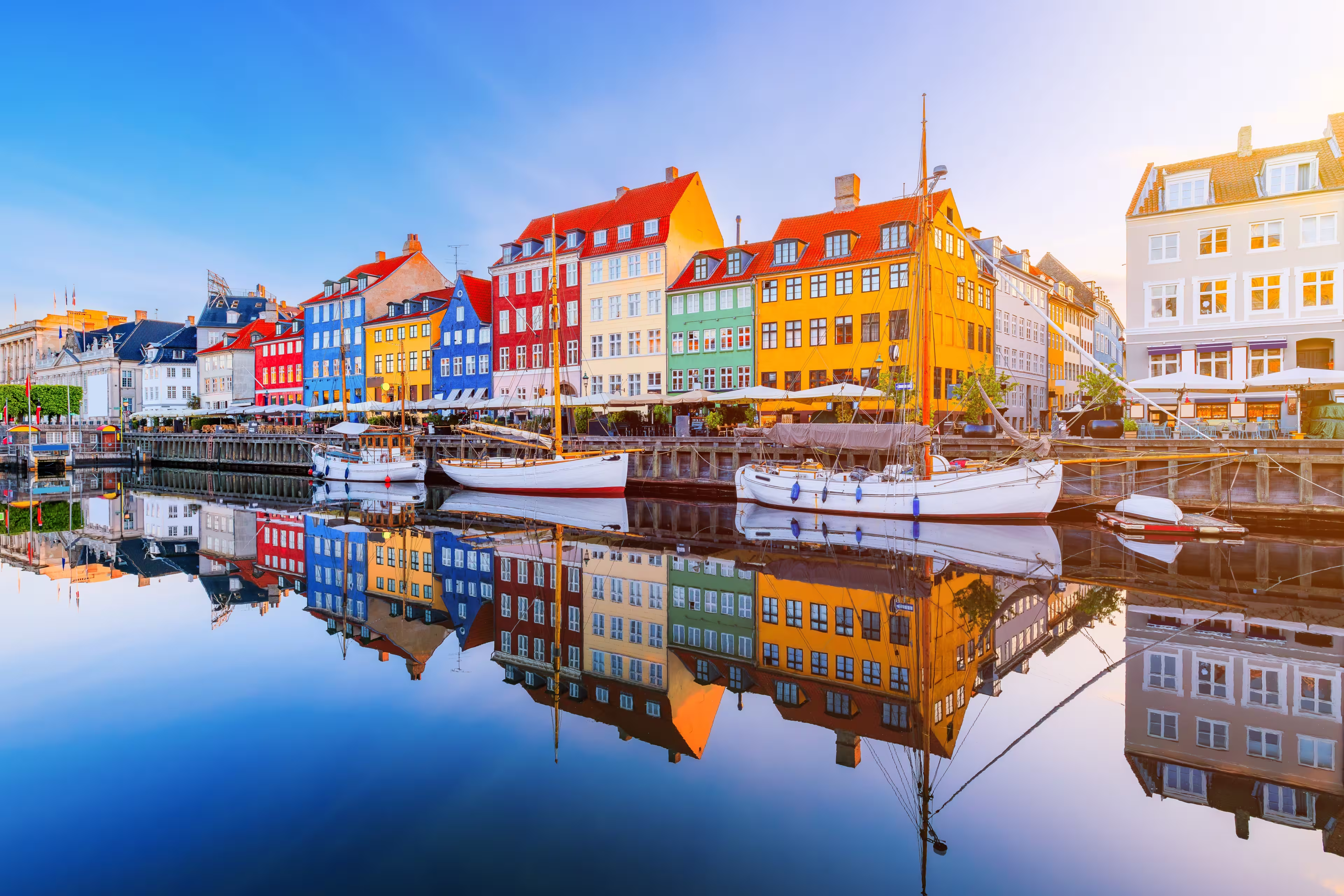 Copenhagen, Denmark. Nyhavn waterfront, colourful buliding facades and old ships along the canal.