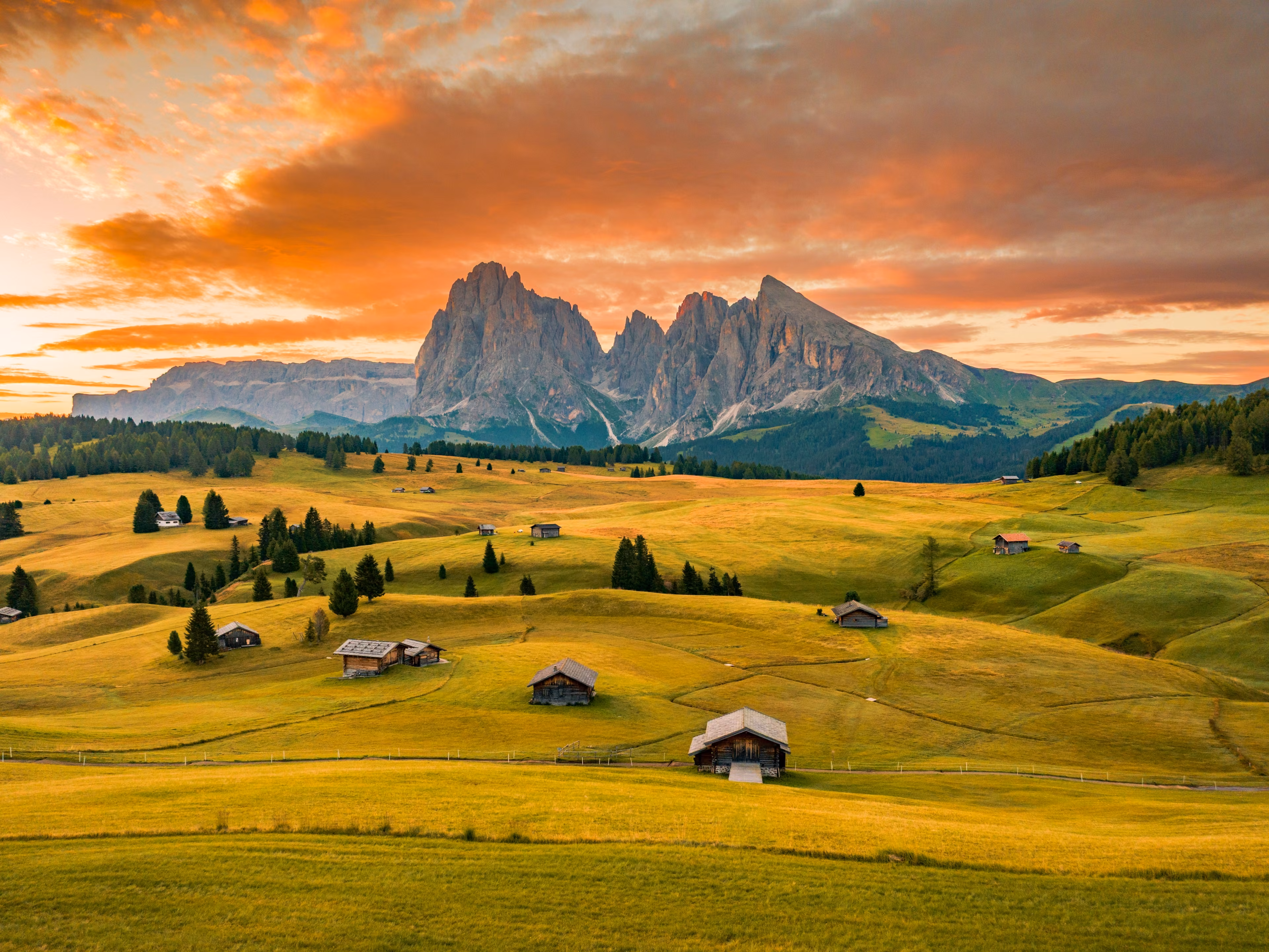 Sunrise over Seiser Alm (Alpe di Siusi), showcasing the breathtaking Dolomites Alps with prominent peaks of Sassolungo and Sassopiatto, located in Trentino Alto Adige, South Tyrol, Italy, Europe