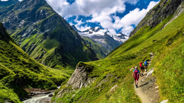 Hiking Group In Valley Of Umbalfaelle On Grossvenediger With View To Mountain Roetspitze In Nationalpark Hohe Tauern In Tirol In Austria