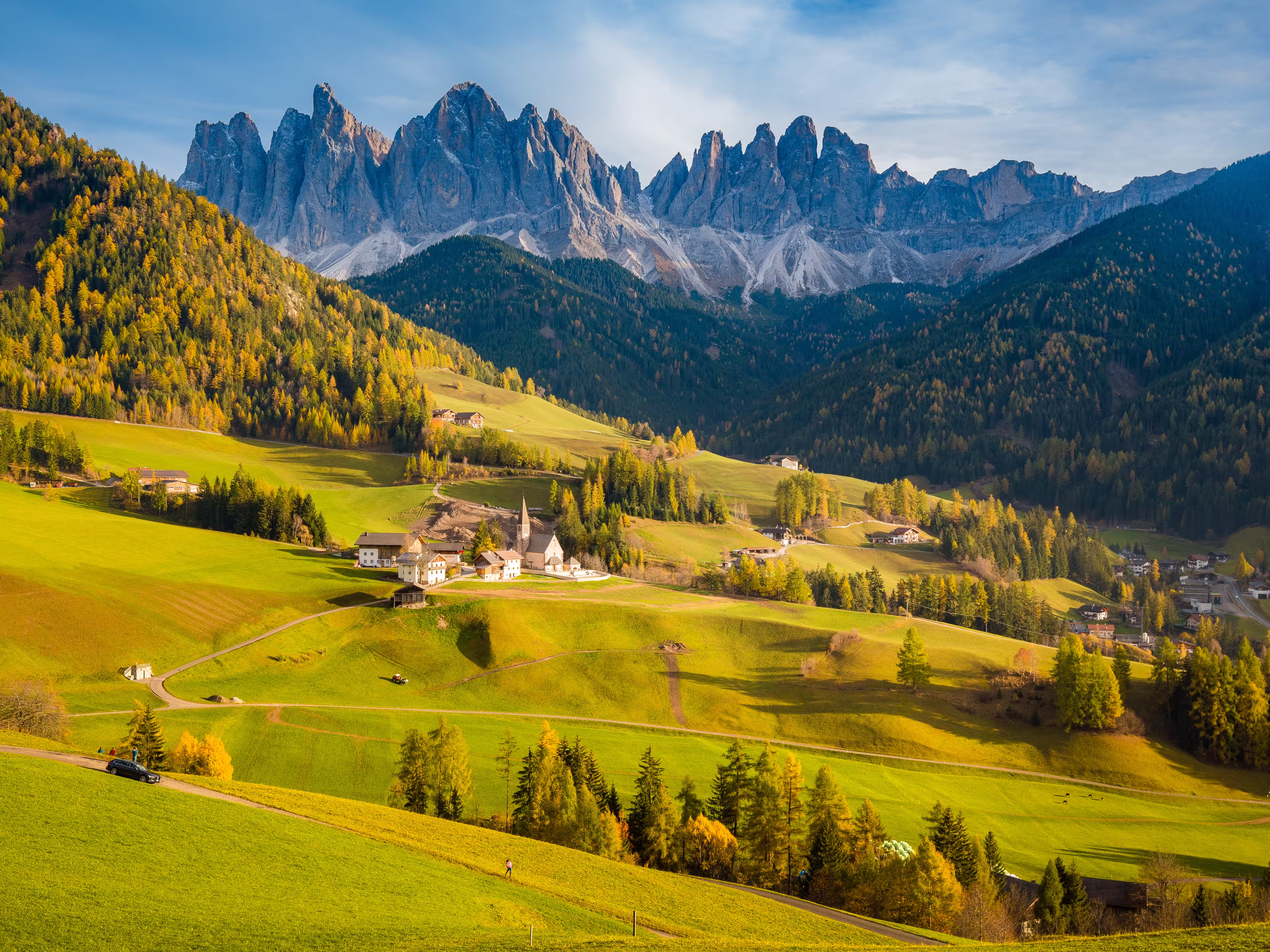 Beautiful view of idyllic mountain scenery in the Dolomites with famous Santa Maddelana mountain village in beautiful golden evening light at sunset in fall, Val di Funes, South Tyrol, northern Italy.