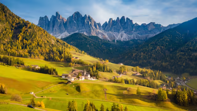 Beautiful view of idyllic mountain scenery in the Dolomites with famous Santa Maddelana mountain village in beautiful golden evening light at sunset in fall, Val di Funes, South Tyrol, northern Italy.