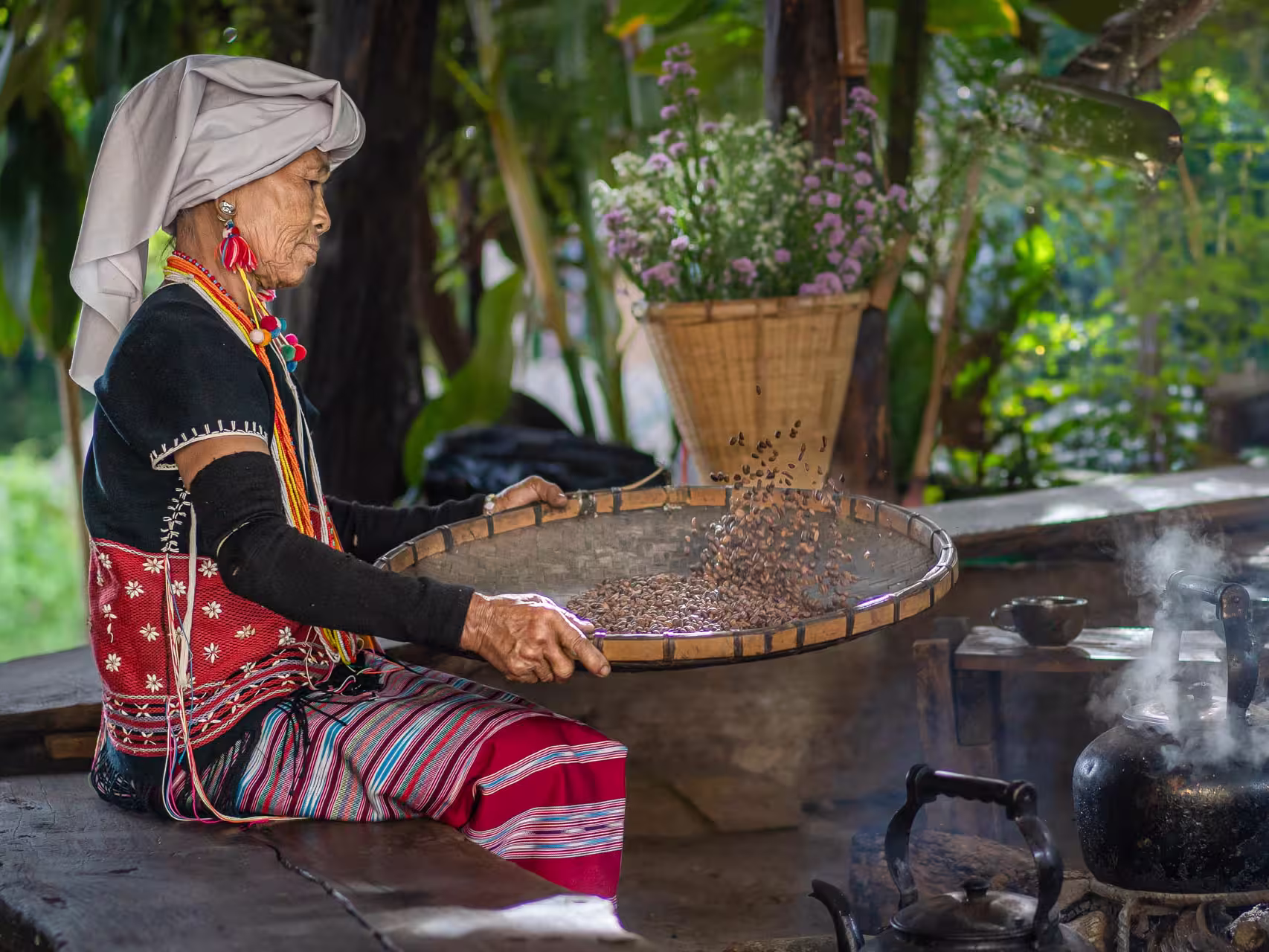 Karen Hill tribe woman tossing coffee beans by a fire