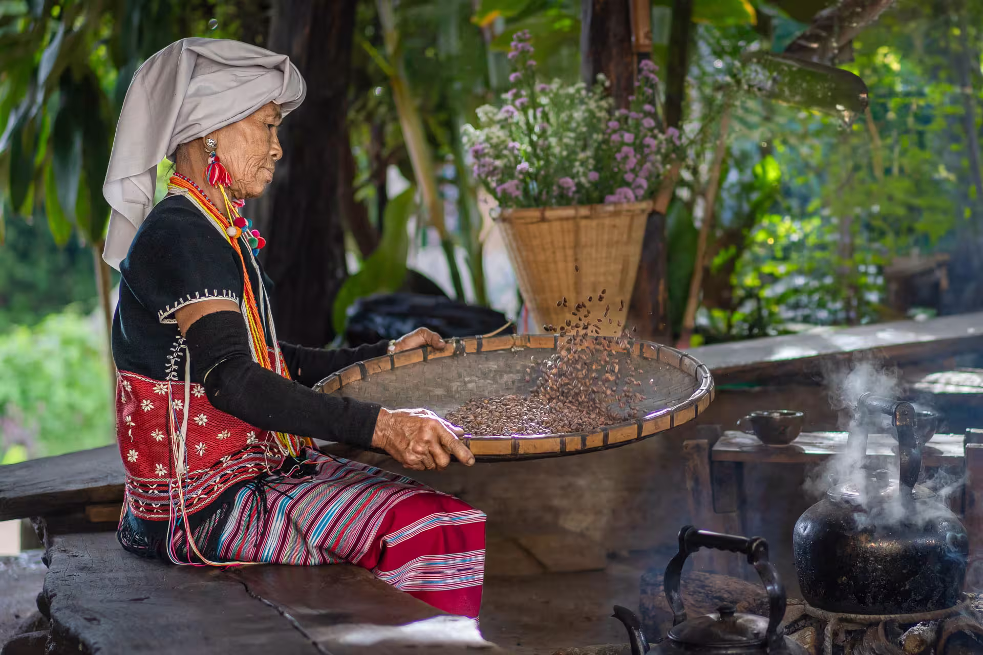 Karen Hill tribe woman tossing coffee beans by a fire