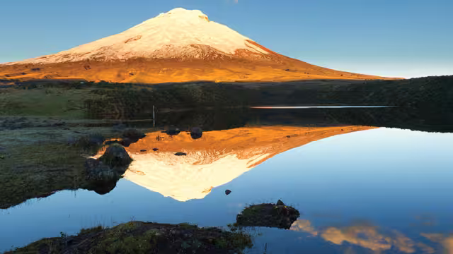View of Cotopaxi volcano and a reflection of it in the lake in front of it, Ecuador