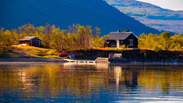 Cottage over the Torneträsk lake,  Tornetrask lake, träsk is a lake in Kiruna Municipality, Lapland, Norrbotten County in Sweden, in the Scandinavian Mountains. Abisko National Park