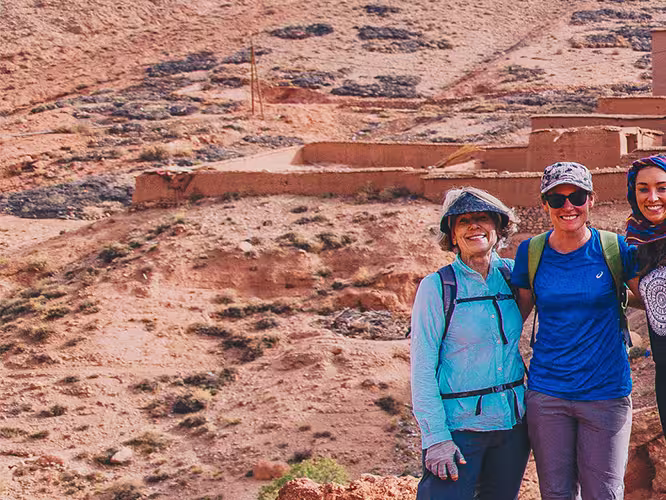 Group of travellers standing before Ait Benhaddou fortified village, Morocco