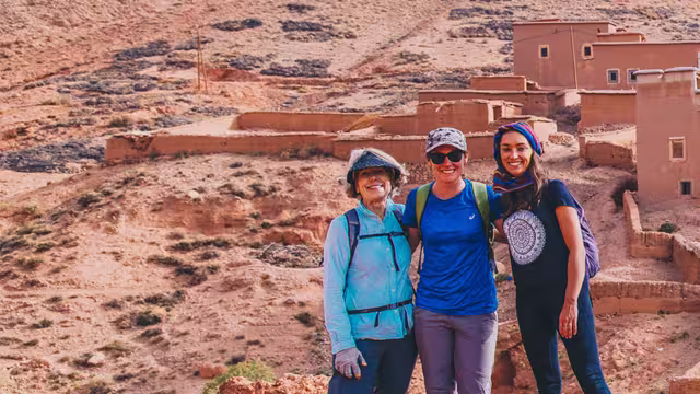 Group of travellers standing before Ait Benhaddou fortified village, Morocco