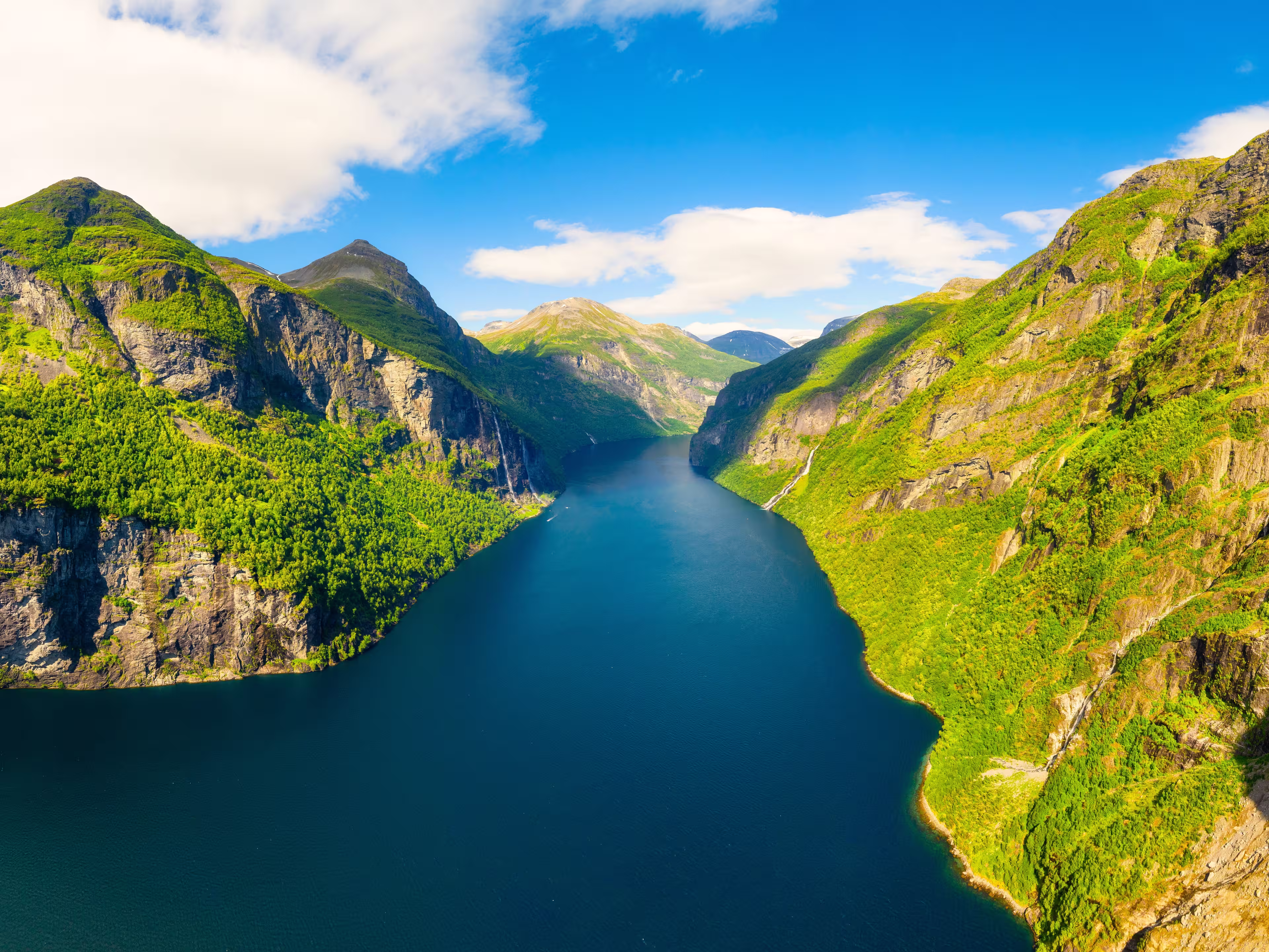 Geiranger Fjord, Norway. Nature in fjords. Traveling by boat on a Norwegian fjord. Scandinavia. View of nature from the drone. Seven Sisters Waterfall. Vacation and travel in summer Norway.
