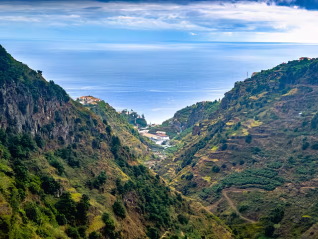 Hinking trail along Levada do Moinho and Levada Nova, revealing lush vegetation, waterfall and water canal to local town.