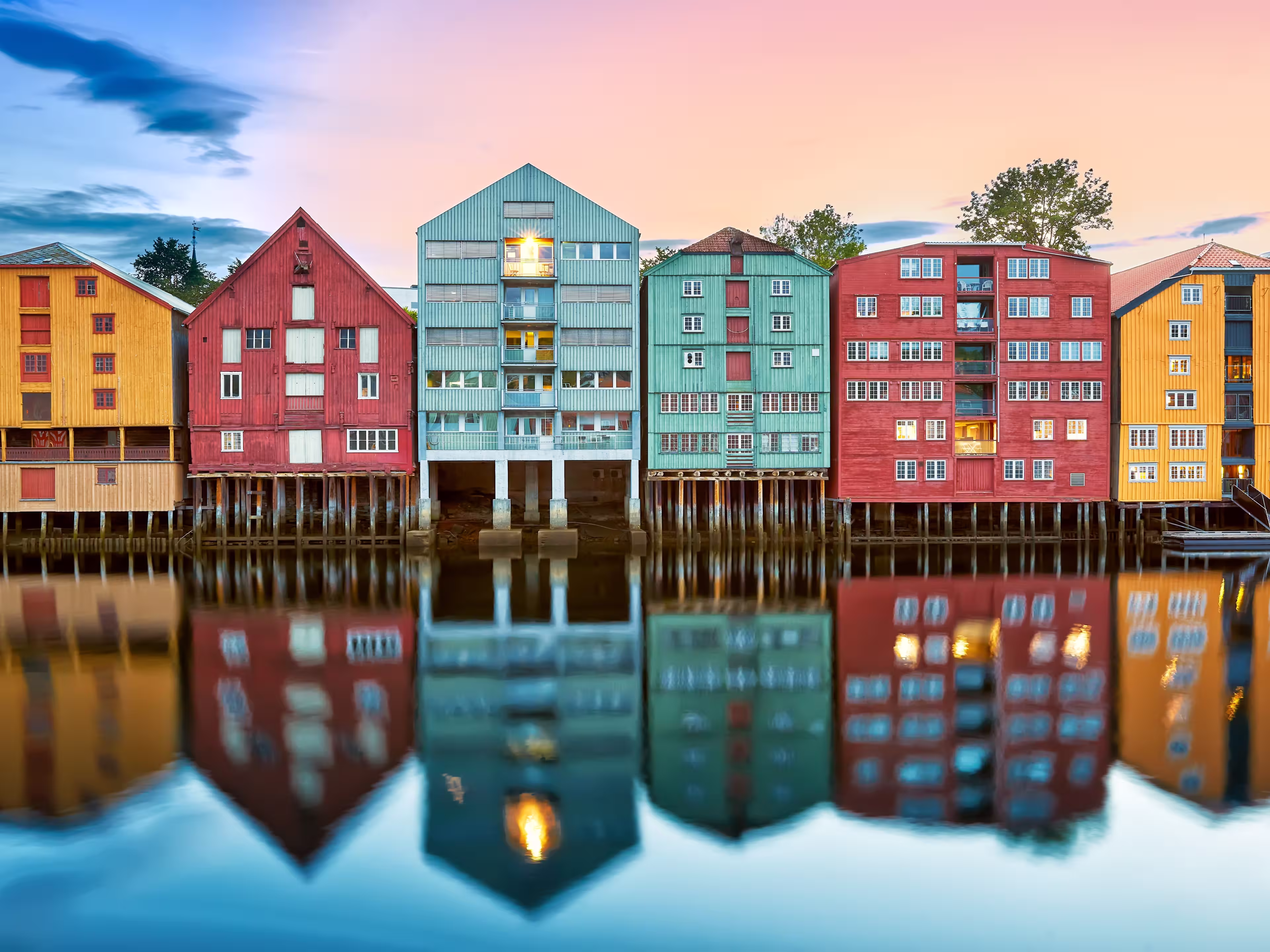Colorful old houses over the Nidelva river at summer sunset in Trondheim, Norway