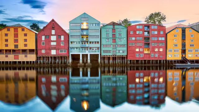 Colorful old houses over the Nidelva river at summer sunset in Trondheim, Norway