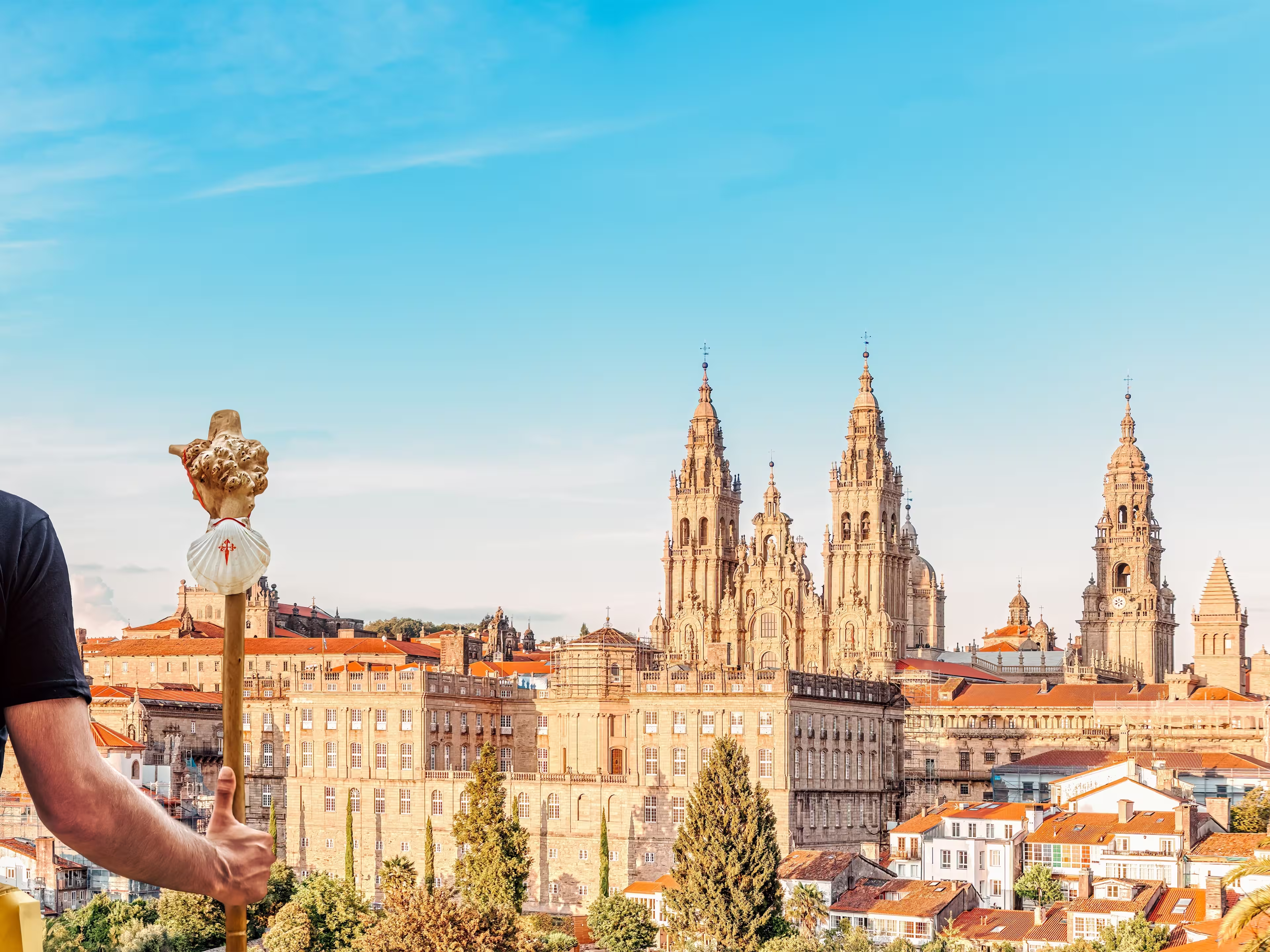 Santiago de Compostela cityscape, Spain - Camino de Santiago pilgrim with yellow backpack arrives at the end of the road