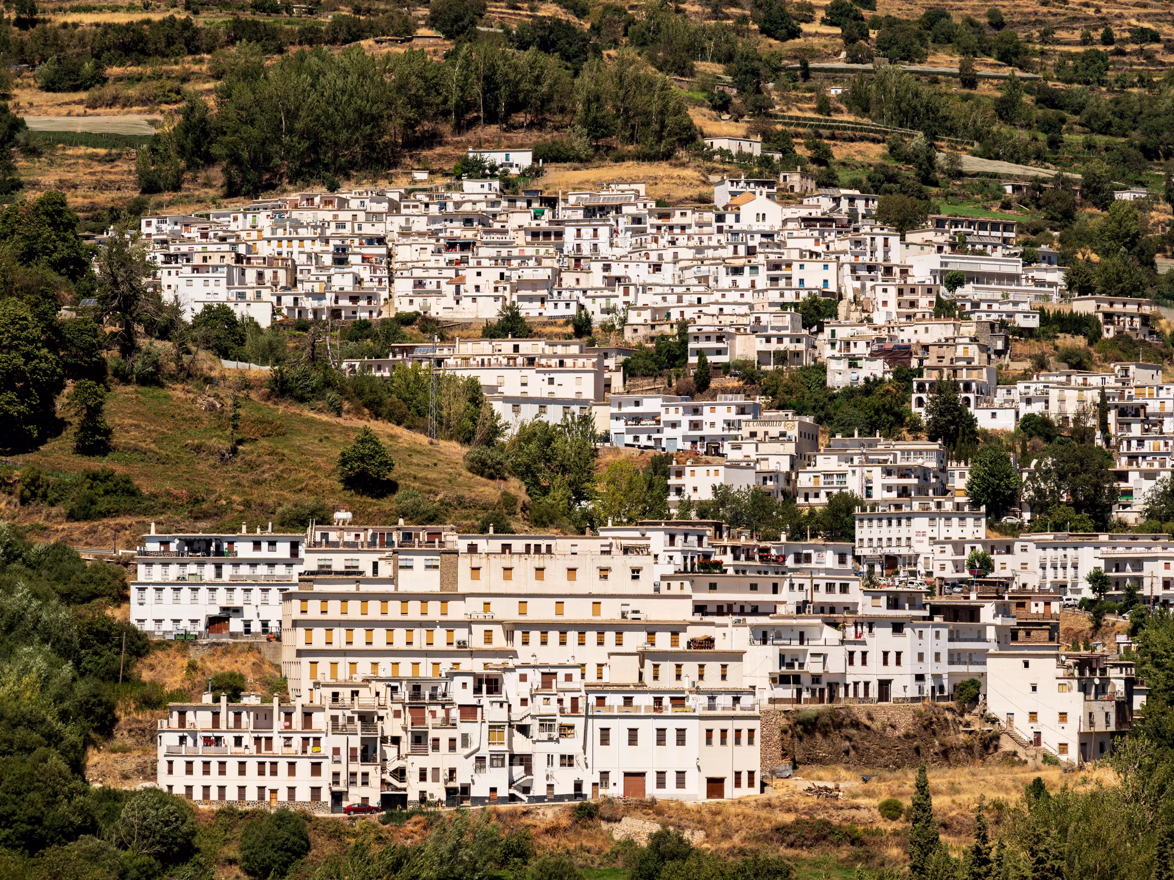 Scenic view of Trevélez village and its white terraced houses, seen from the other side of the Río Trevélez valley, Las Alpujarras, Sierra Nevada National Park, Andalusia, Spain