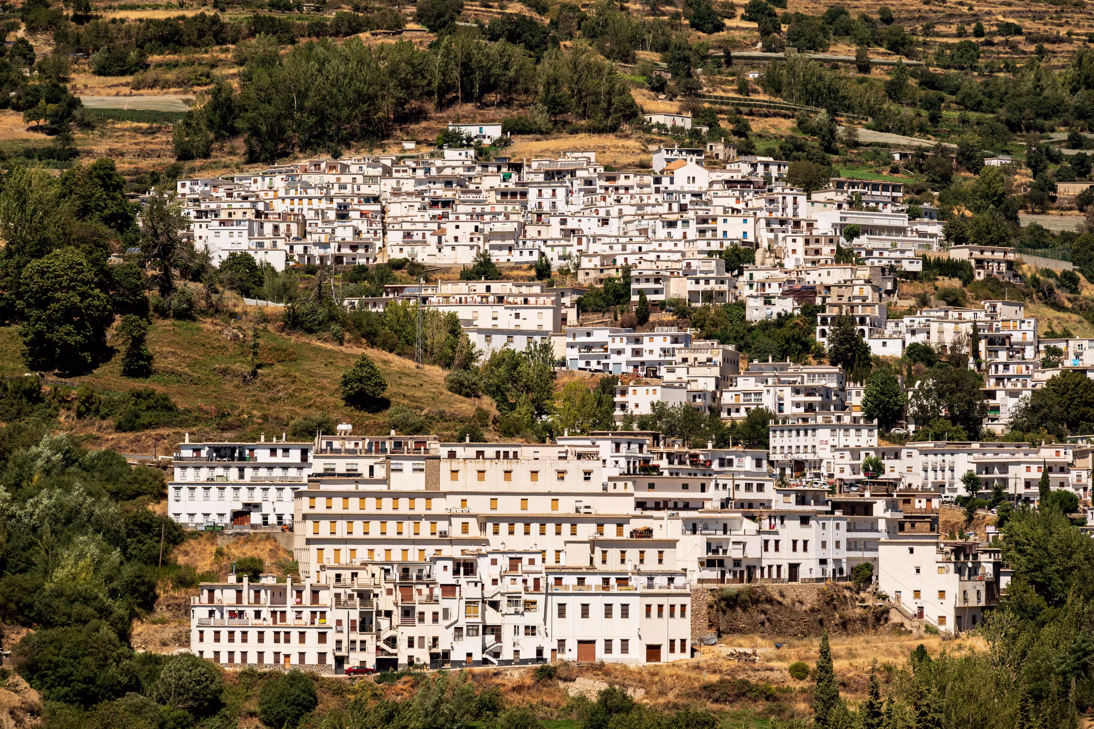 Scenic view of Trevélez village and its white terraced houses, seen from the other side of the Río Trevélez valley, Las Alpujarras, Sierra Nevada National Park, Andalusia, Spain