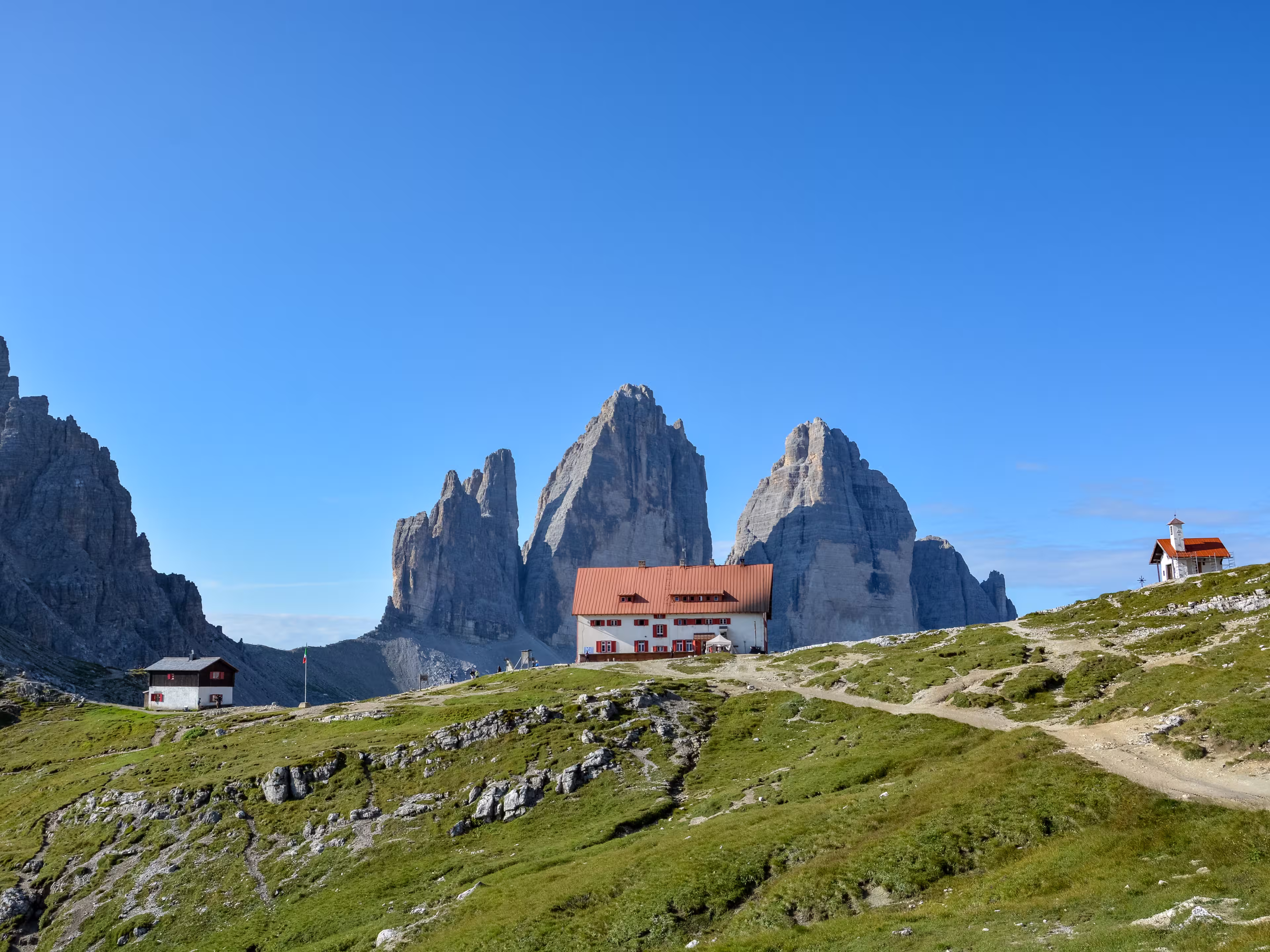 The famous mountains Three Peaks in the Dolomites with the alpine hut Dreizinnenhuette  in the front