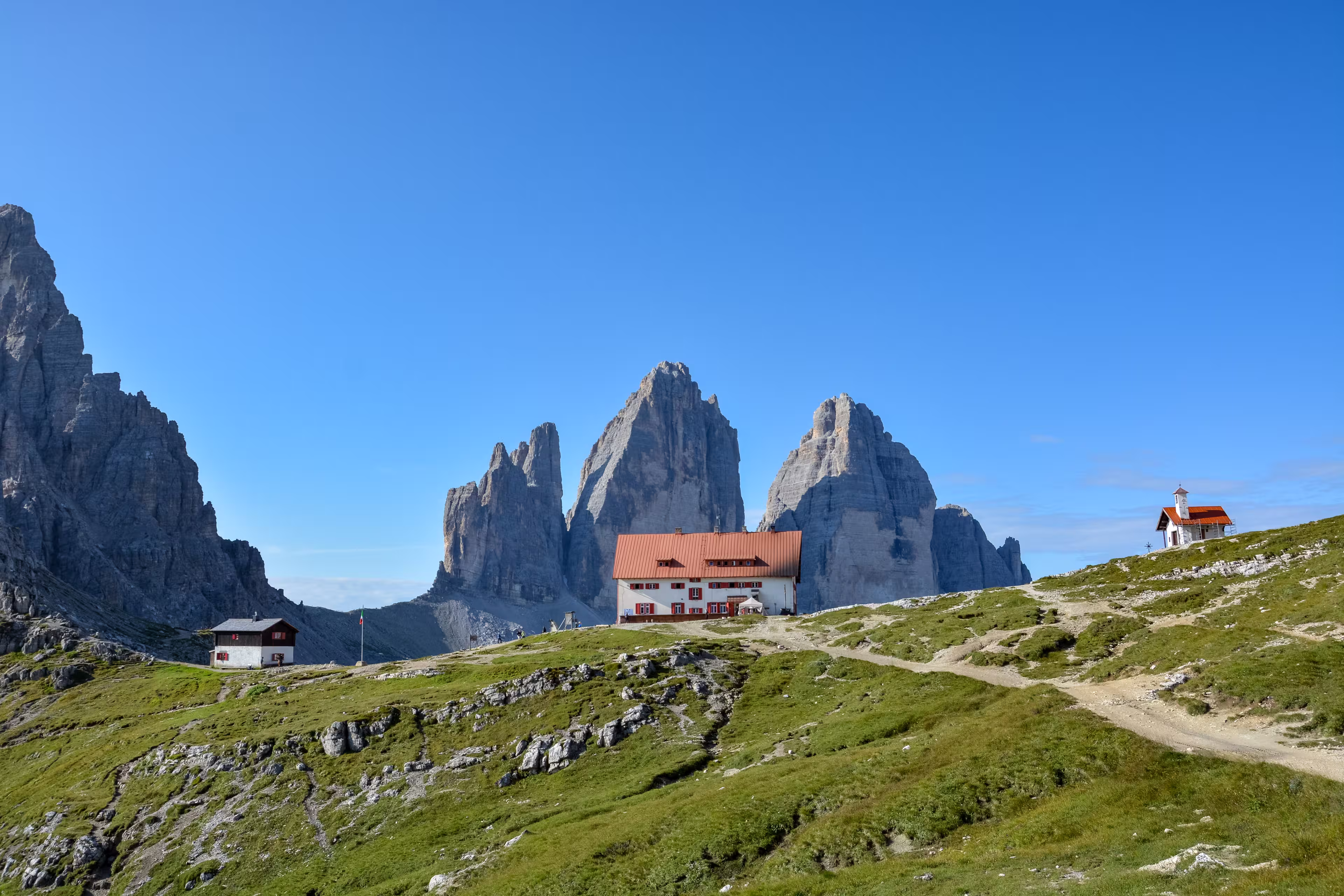 The famous mountains Three Peaks in the Dolomites with the alpine hut Dreizinnenhuette  in the front