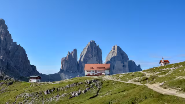 The famous mountains Three Peaks in the Dolomites with the alpine hut Dreizinnenhuette in the front