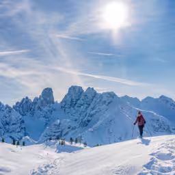 active senior woman snowshoeing from Prato Piazzo up to the Monte Specie in the three oeaks Dolomites area near village of Innichen, South Tyrol, Italy
