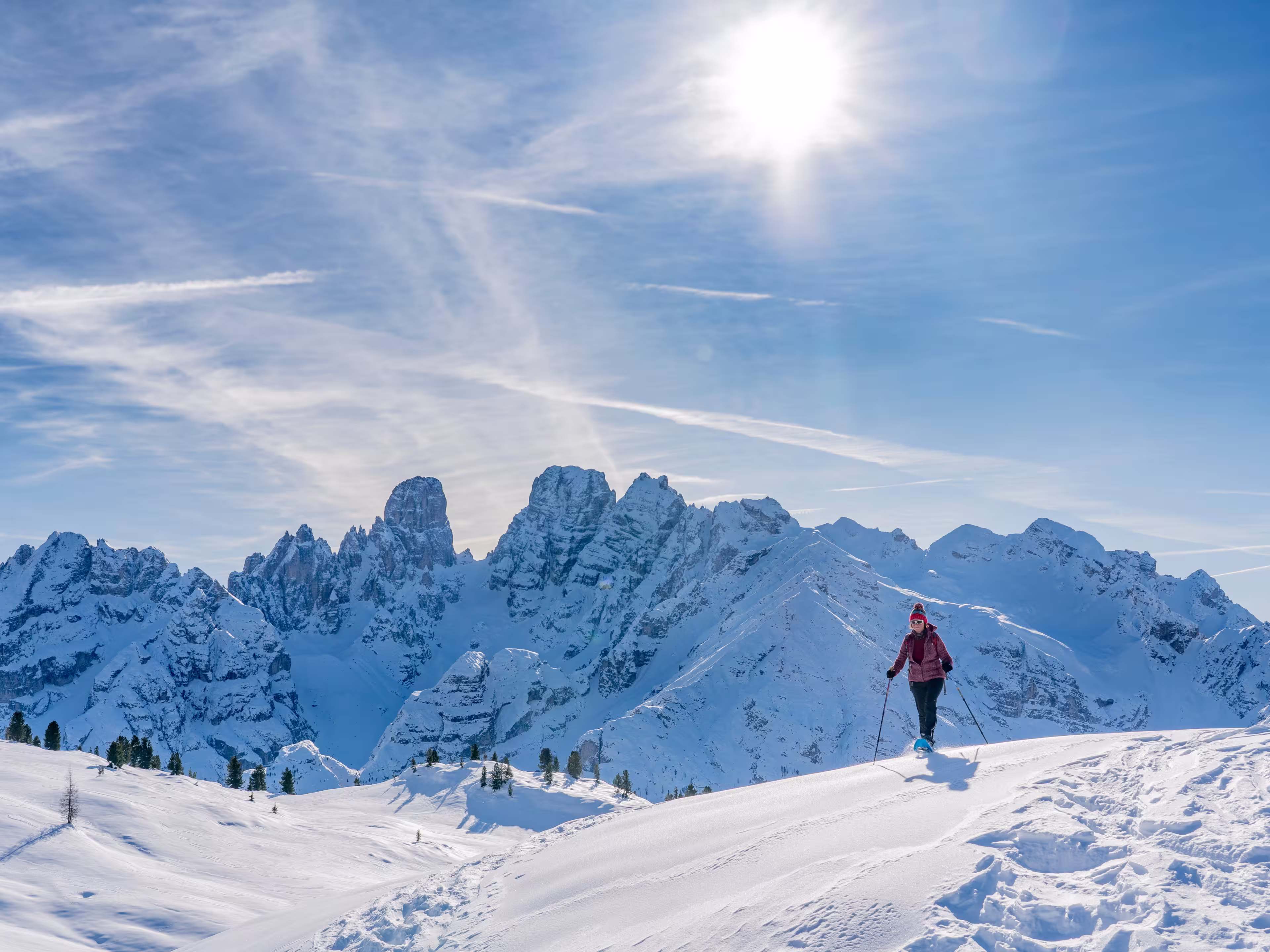 active senior woman snowshoeing from Prato Piazzo up to the Monte Specie in the three oeaks Dolomites area near village of Innichen, South Tyrol, Italy