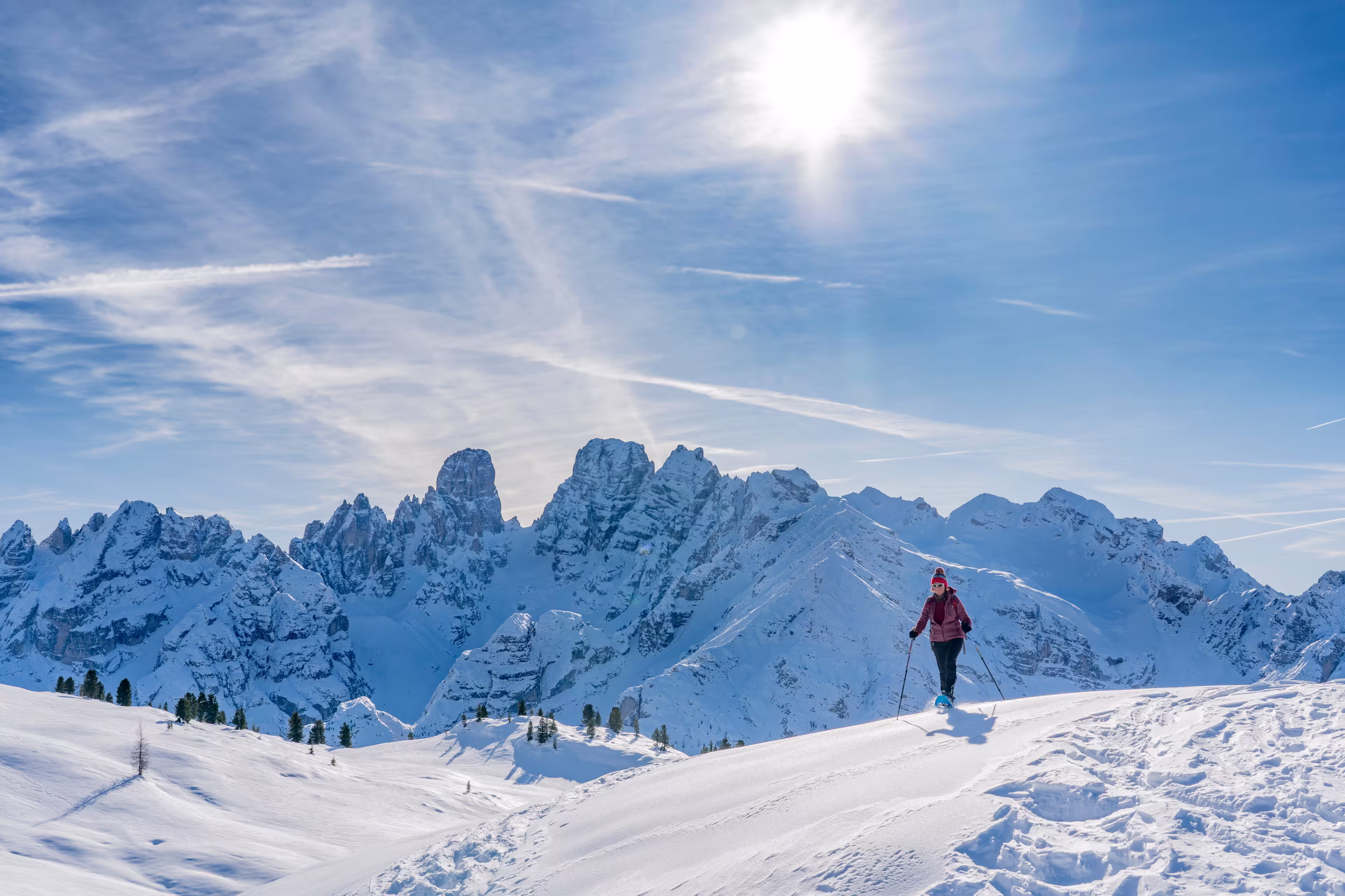 active senior woman snowshoeing from Prato Piazzo up to the Monte Specie in the three oeaks Dolomites area near village of Innichen, South Tyrol, Italy