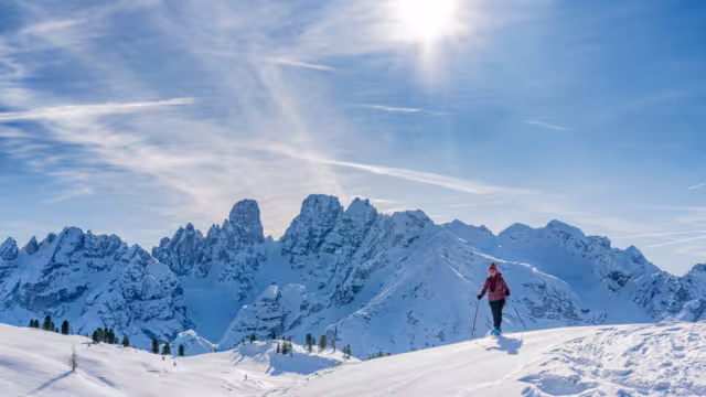 active senior woman snowshoeing from Prato Piazzo up to the Monte Specie in the three oeaks Dolomites area near village of Innichen, South Tyrol, Italy