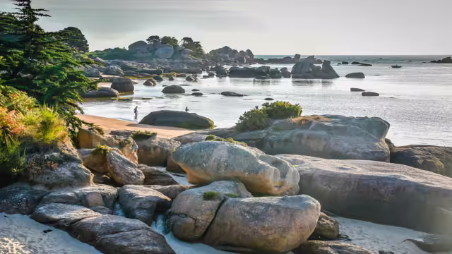 Dawn light at Ty-Lia Beach on the Ile Renote facing Saint Anne Bay (Biae de Sanite Anne) near the coastal village of Tregastel on the Red Granite Coast of northern Brittany, France.