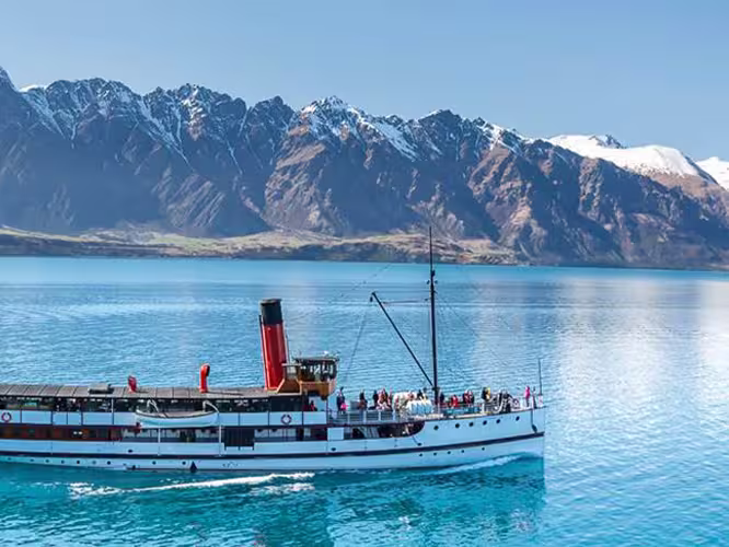 Boat by Queenstown with beautiful mountain backdrop, South Island, New Zealand