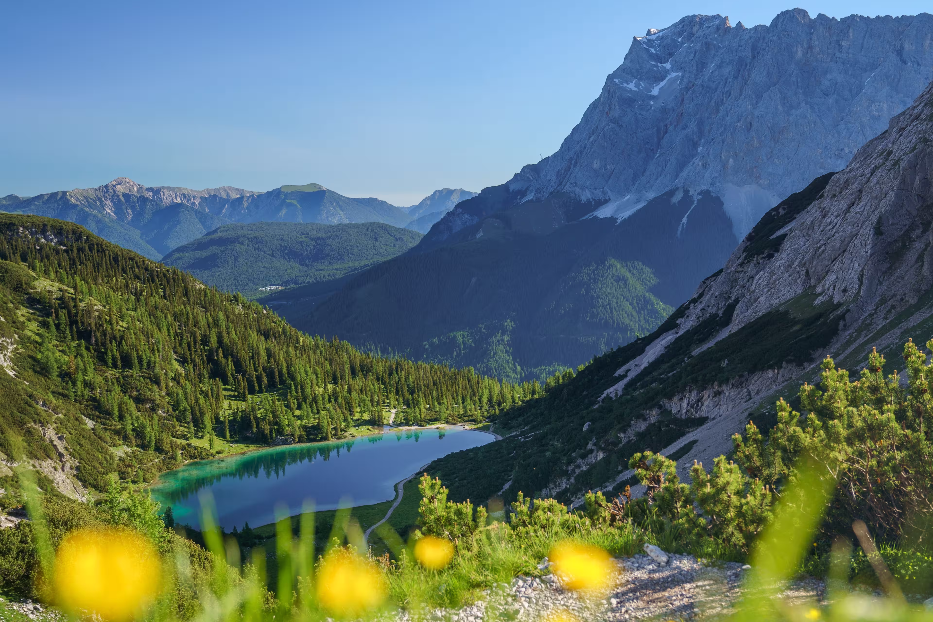 The Seebensee in Tirol, Austria, is surrounded by the high mountains of the Mieminger Range. In the background the Zugspitze and the Wetterstein Mountains. Seen from the Coburger Hütte.