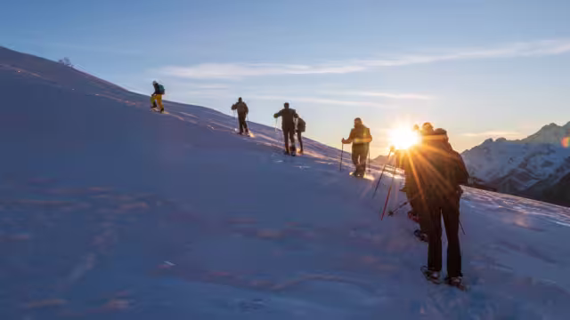 the group of snowshoes faces the climb up the snowy side of the mountain