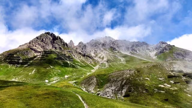 St. Anton am Arlberg hiking mountains grass wood and rocky terrain cloudy sky sunlight