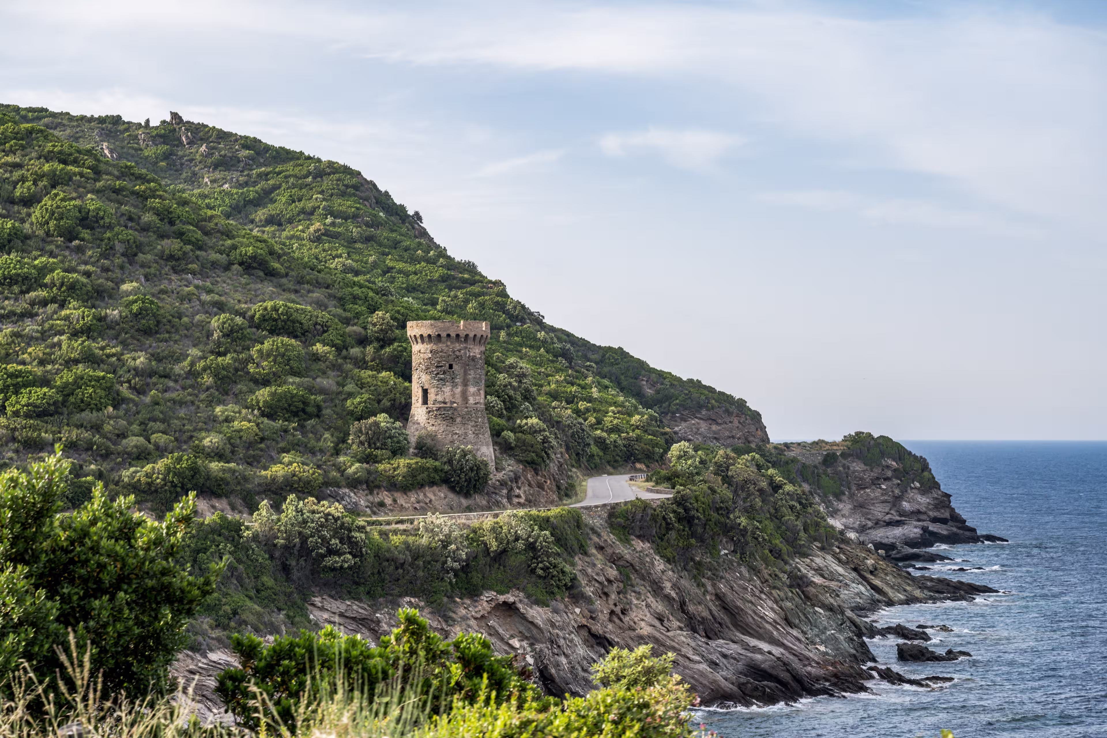Watchtower view Roadtrip Winding road along rocky coast of Cap Corse peninsula on Corsica island France